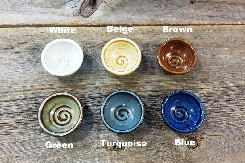 Puede incluir: Seis peque&ntilde;os cuencos de cer&aacute;mica con un dise&ntilde;o de espiral en varios colores: blanco, beige, marr&oacute;n, verde, turquesa y azul.