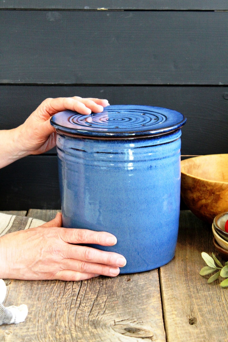 Puede incluir: Un tarro de cer&aacute;mica azul con tapa. La tapa tiene una serie de peque&ntilde;os agujeros. El tarro est&aacute; esmaltado en un color azul claro y tiene un borde marr&oacute;n.