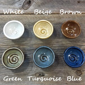 K&ouml;nnte beinhalten: Sechs kleine Keramikschalen mit einem Spiraldesign in verschiedenen Farben: Wei&szlig;, Beige, Braun, Gr&uuml;n, T&uuml;rkis und Blau.