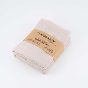 May include: A set of three beige cotton muslin washcloths, folded and packaged with a brown label that reads "CHEEKSAHOY organics cotton muslin WASHCLOTHS SET of 3 Handmade in Canada / Fait &agrave; la main au Canada."