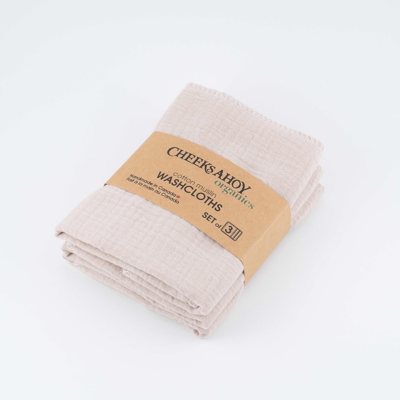 May include: A set of three beige cotton muslin washcloths, folded and packaged with a brown label that reads "CHEEKSAHOY organics cotton muslin WASHCLOTHS SET of 3 Handmade in Canada / Fait &agrave; la main au Canada."