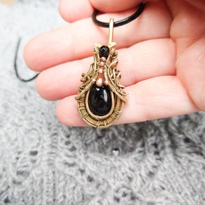 Small  brass and black obsidian pendant.