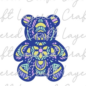 May include: A blue teddy bear with a colorful mandala pattern. The pattern includes shades of yellow, green, pink, and purple.