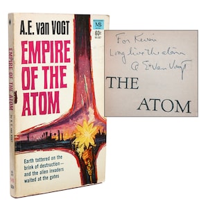 May include: A vintage paperback book cover for the science fiction novel "Empire of the Atom" by A.E. van Vogt. The cover features a futuristic cityscape with a bright yellow star in the sky. The book is signed by the author with a dedication to Kevin.
