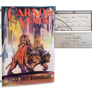 May include: A vintage copy of "Carson of Venus" by Edgar Rice Burroughs, with a colourful cover illustration of a fantasy scene. Includes a handwritten note and a typed letter. The book's spine is visible.