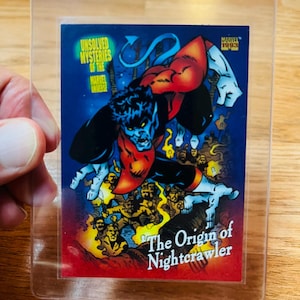 May include: A trading card featuring Nightcrawler from the Marvel Universe, protected in a clear plastic sleeve. The card has a blue background with the text "Unsolved Mysteries of the Marvel Universe" and "The Origin of Nightcrawler."