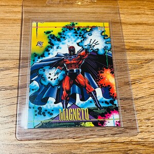 May include: A trading card featuring the Marvel Comics character Magneto. The card shows Magneto in a red and purple costume, with a blue cape, and the word "MAGNETO" in gold lettering. The background is a mix of yellow, blue, and orange.