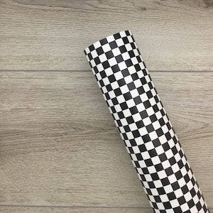 May include: A roll of black and white checkered wrapping paper. The paper is rolled up and the end is visible.