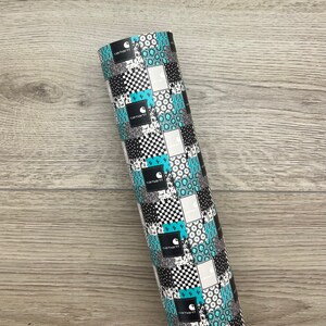 May include: A roll of black and white patterned wrapping paper with a turquoise and white geometric design. The paper features the Carhartt logo repeated throughout the pattern.