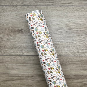 May include: A white vinyl sheet with a repeating pattern of school-themed illustrations. The illustrations include a school bus, pencils, apples, books, globes, and other school supplies. The pattern is in shades of yellow, red, blue, and green.