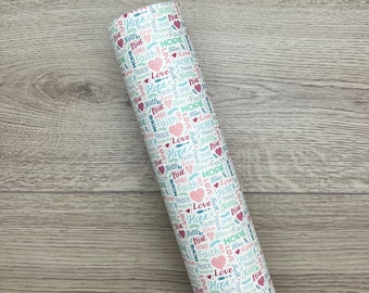 May include: White wrapping paper with a repeating pattern of the words "love", "hope", and "faith" in various colors and fonts. The words are interspersed with small hearts in pink and red.