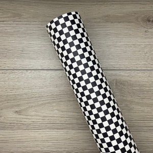 May include: A roll of black and white checkered vinyl adhesive. The vinyl is perfect for crafting and decorating.