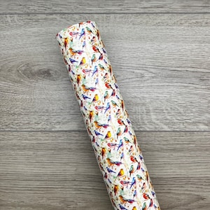 May include: A white roll of wrapping paper with a colorful bird pattern. The birds are in various shades of blue, red, yellow, and green.