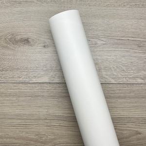 May include: A roll of white vinyl adhesive backed craft paper. The paper is rolled up and has a smooth, matte finish.