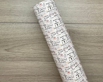 May include: Rolled paper with a repeating pattern of crosses, roses, and text. The text includes phrases like "Jesus is King," "Child of God," and "God is Good." The color scheme is primarily white, with black text and pink floral accents.