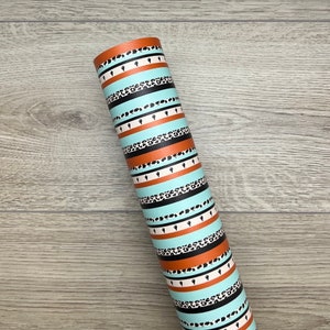 May include: A roll of turquoise and orange patterned wrapping paper with black and white animal print stripes and cactus silhouettes.