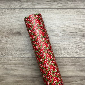 May include: Roll of red wrapping paper with a repeating pattern of candy canes and holly leaves.