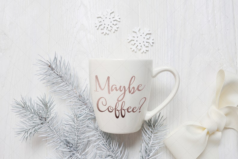 Pu&ograve; includere: Tazza da caff&egrave; in ceramica bianca con il testo "Maybe Coffee?" in lettere rosa oro. La tazza &egrave; circondata da rami di pino bianchi e fiocchi di neve bianchi.