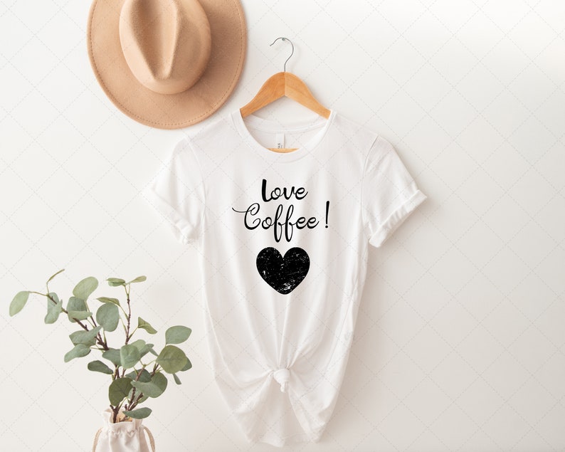 Pu&ograve; includere: Maglietta bianca con testo nero che dice "Love Coffee!" e un grafico a forma di cuore nero.