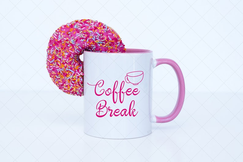 Pu&ograve; includere: Una tazza da caff&egrave; bianca con un bordo e un manico rosa. La tazza ha il testo "Coffee Break" in lettere rosa e un piccolo contorno di una tazzina da caff&egrave;. Un ciambellone rosa con codette colorate &egrave; parzialmente nella tazza.