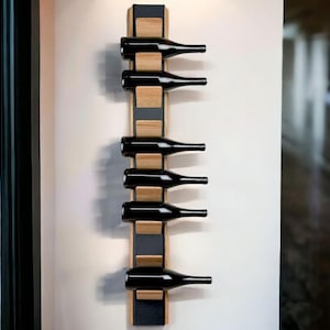 Pode incluir: Um suporte de vinho de parede com um design preto e madeira. O suporte tem capacidade para seis garrafas de vinho.