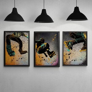 May include: Three framed art prints featuring abstract illustrations of people skateboarding. The prints are set against a yellow and brown background with black outlines and splashes of colour.