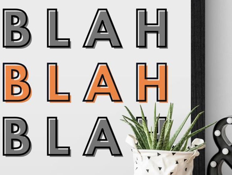 May include: A white framed print with the word "BLAH" repeated three times in black and orange lettering.