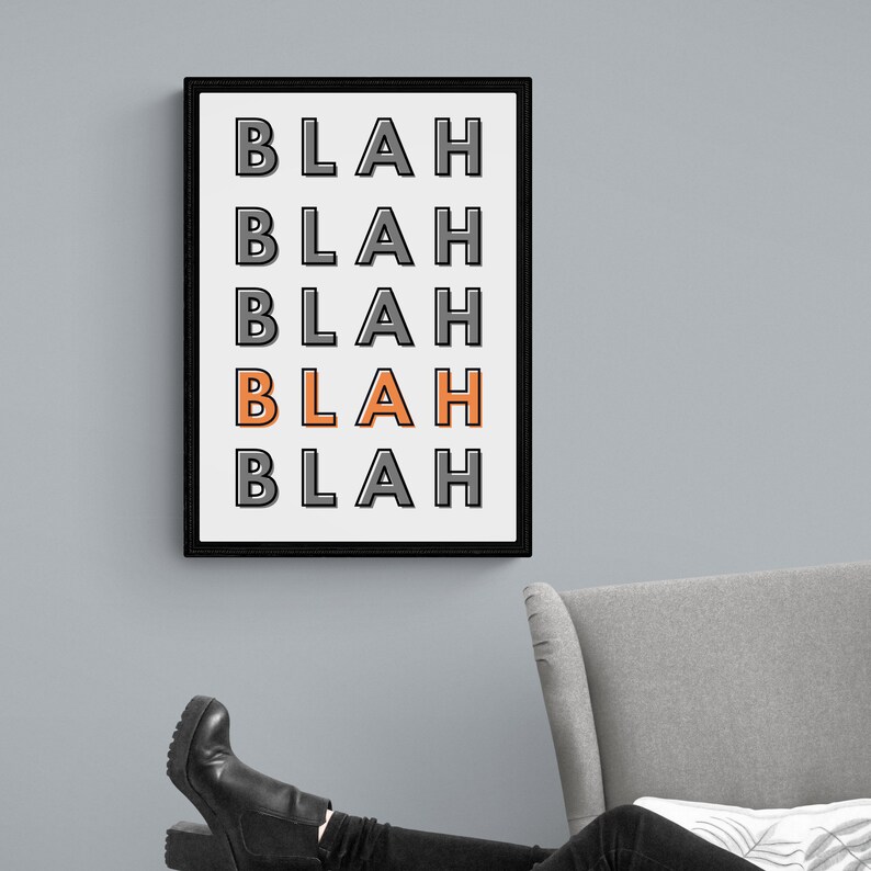 May include: A black framed print with the word "BLAH" repeated five times in a vertical stack. The fourth "BLAH" is in orange.