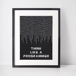 May include: A framed print with a black frame. The print features a binary code design at the top and the words "THINK LIKE A PROGRAMMER" in white at the bottom, set against a black background.