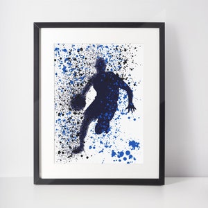 May include: A blue silhouette of a basketball player dribbling a ball, with a white background and blue and black paint splatters.
