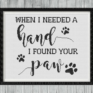 以下が含まれることがあります： 「When I needed a hand I found your paw」というテキストと肉球の跡が描かれた白黒のクロスステッチデザインです。