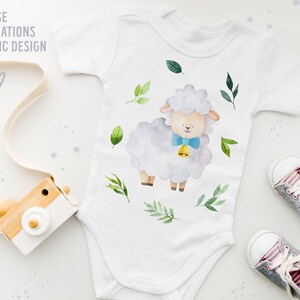 Pu&ograve; includere: Un body bianco per neonato con un'illustrazione ad acquerello di una pecora che indossa un papillon blu e un campanello. La pecora &egrave; circondata da foglie verdi. Il body &egrave; sdraiato su una superficie bianca con una macchina fotografica giocattolo di legno e un paio di scarpe da ginnastica grigie.