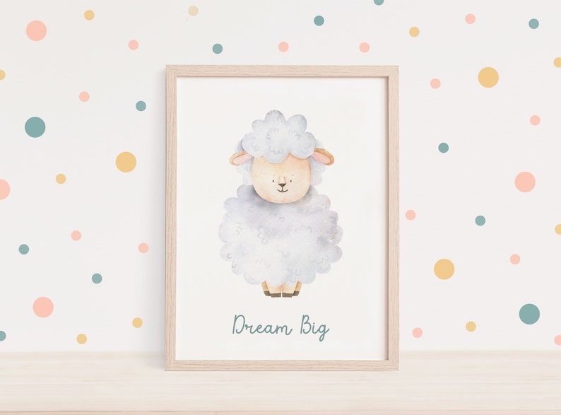 Pu&ograve; includere: Un'illustrazione ad acquerello di una pecora bianca su uno sfondo blu chiaro. La pecora &egrave; in piedi su una superficie bianca e il testo "Dream Big" &egrave; scritto sotto la pecora in blu chiaro.