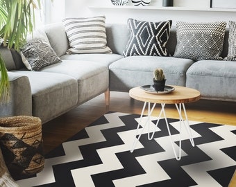 May include: Black and white chevron patterned rug with a white coffee table and a gray sectional sofa with black and white patterned pillows.