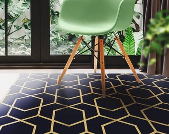 May include: A navy blue and gold geometric patterned rug with a green chair sitting on top of it.