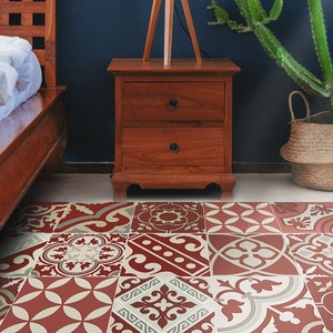Puede incluir: Una alfombra de área roja y crema con un diseño geométrico. La alfombra está en un dormitorio con una cama y una mesita de noche de madera.