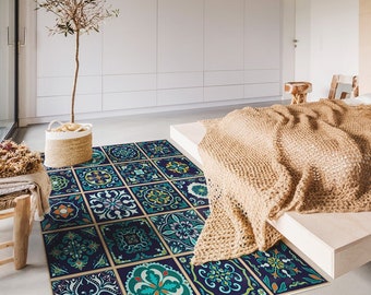 May include: A blue and green patterned rug with a geometric design. The rug is in a bedroom with a bed and a wooden side table.