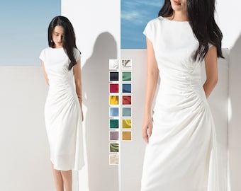 May include: A white midi dress with a gathered detail on the side. The dress has a round neckline and short sleeves. The dress is shown on a model against a white background. The image also includes a color chart with 16 different color options for the dress.