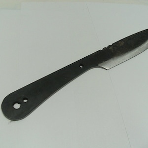 May include: A black knife with a rounded handle and a serrated edge. The handle has two holes for attaching a lanyard.