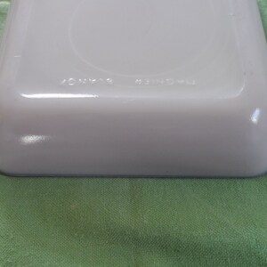 May include: White rectangular baking dish with a blue rim. The bottom of the dish has the words "ONYX" and "MADE IN USA" printed on it.