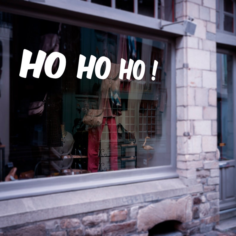 Puede incluir: Un escaparate de tienda con el texto "HO HO HO!" mostrado en letras blancas. El escaparate refleja una variedad de prendas de vestir y accesorios.