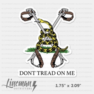 May include: A yellow and black snake coiled around two crossed climbing axes with the words "Don't Tread On Me" below. The sticker is 1.75 inches by 2.09 inches.