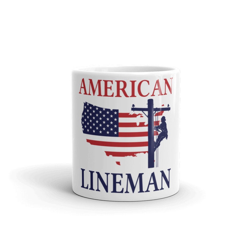 Puede incluir: Taza de cer&aacute;mica blanca con un dise&ntilde;o de bandera estadounidense roja, blanca y azul y el texto "AMERICAN LINEMAN".