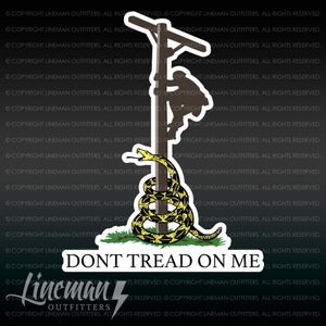 May include: A yellow and black snake wrapped around a wooden utility pole with a silhouette of a person climbing the pole. The snake is coiled around the pole and has a 'Don't Tread On Me' inscription below it.