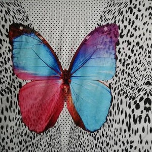 May include: A white fabric with a black and white leopard print pattern. Two large butterflies are printed on the fabric. The butterflies have blue, pink, and purple wings.