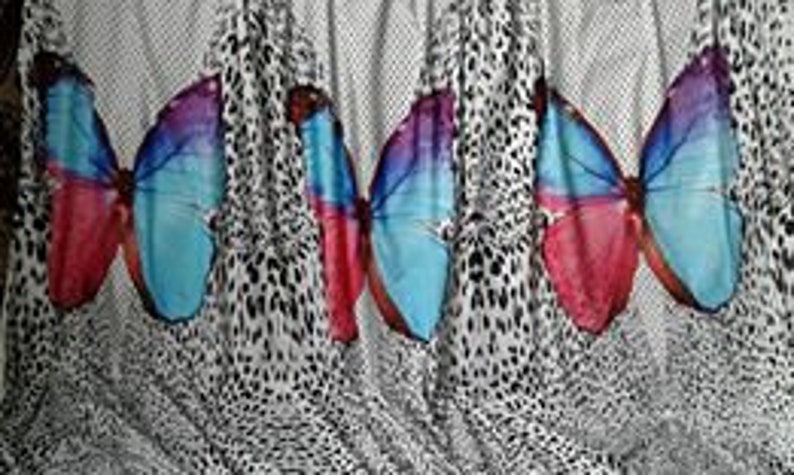 May include: White fabric with a repeating pattern of colorful butterfly silhouettes on a black and white leopard print background.