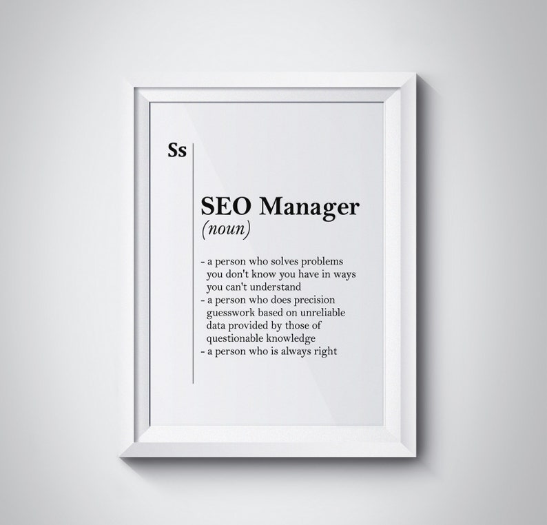 May include: A white framed print with the text "SEO Manager (noun)" and a definition of the term. The definition includes phrases like "solves problems you don't know you have", "precision guesswork", and "unreliable data".