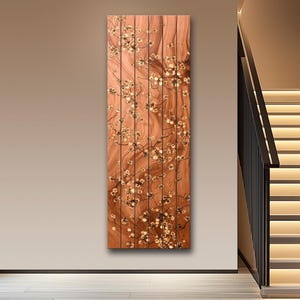 May include: A vertical wooden art piece with a warm brown tone, featuring a floral design. The artwork is composed of several vertical wooden panels, with a pattern of delicate white and gold flowers.