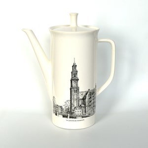 Könnte beinhalten: Weiße Kaffeekanne aus Keramik mit einer Schwarzweißillustration eines Kirchturms und dem Text "Westertoren" auf der Vorderseite.