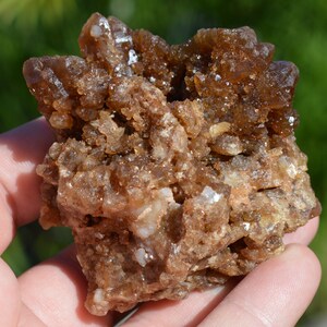 Könnte beinhalten: Ein Cluster aus braunen und klaren Quarzkristallen mit einer rauen, natürlichen Textur. Die Kristalle sind in einer zufälligen Formation zusammengefügt und bilden ein einzigartiges und interessantes Stück.